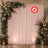 Elegant floral wedding backdrop with pink drapes and lanterns, flame retardant sign