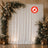 Elegant floral wedding backdrop with white drapery and lanterns, flame-retardant sign