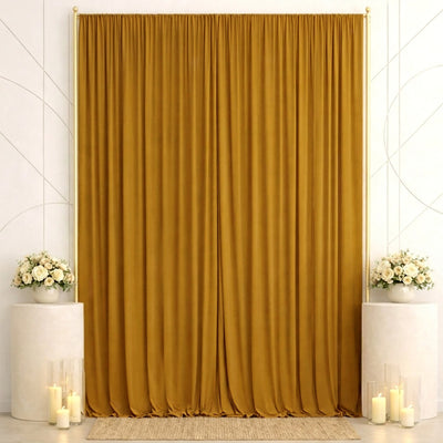 Elegant gold curtain backdrop with white floral arrangements and candles