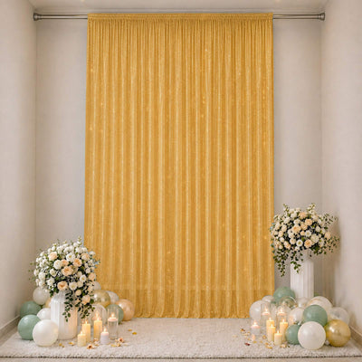 Elegant gold event backdrop with floral arrangements, candles, and pastel balloons