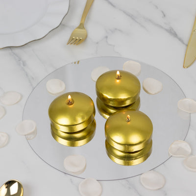 Gold decorative candles on a mirrored surface with rose petals.
