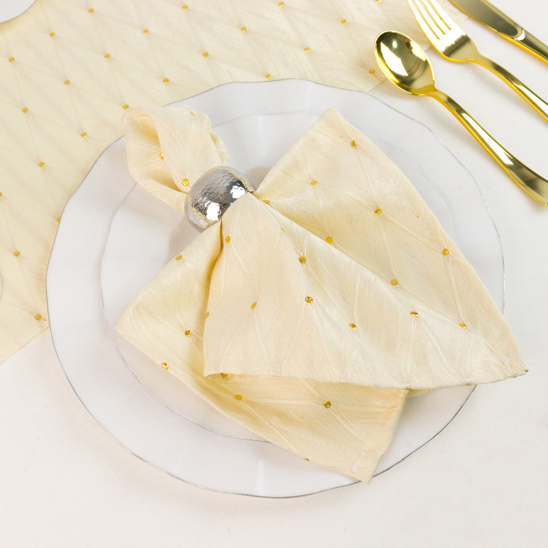 Elegant gold polka dot napkin with silver ring and gold cutlery table setting