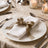 Elegant gold ribbon tied around silver cutlery on a white table settings