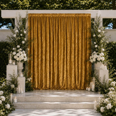 Elegant gold wedding backdrop with white floral arrangements and candles