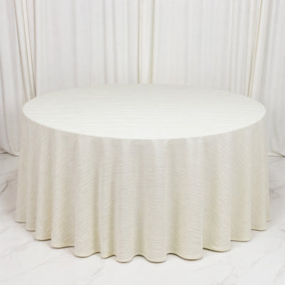 Elegant ivory round table with textured drape and white backdrop