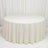 Elegant ivory round table with textured drape and white backdrop