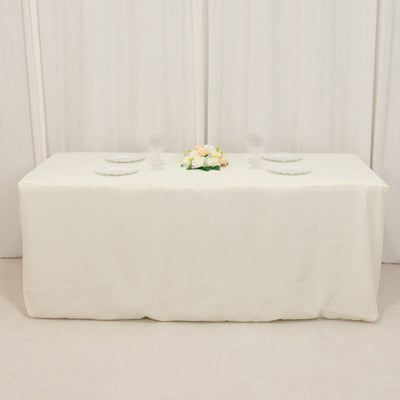 Elegant white table setup with floral centerpiece and glassware.