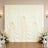 Elegant ivory wedding drapery backdrop with floral arrangements and chairs