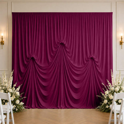 Elegant magenta draped backdrop with floral wedding decor and wall sconces
