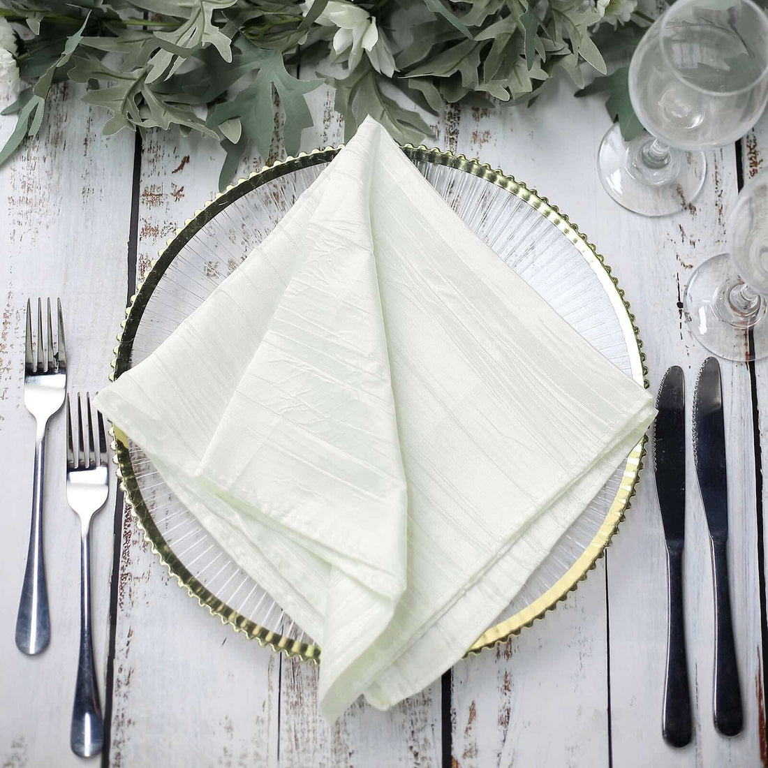 Elegant light green napkin neatly folded on a decorative plate with cutlery. #whtbkgd