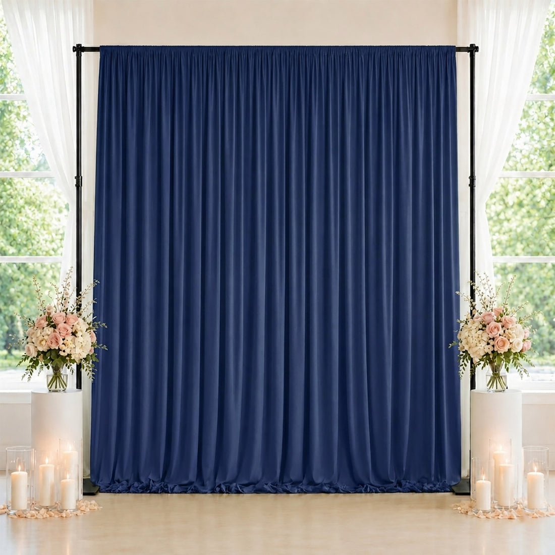 Elegant navy blue curtain backdrop with floral arrangements and candles