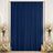 Elegant navy blue curtain backdrop with white floral arrangements and candles
