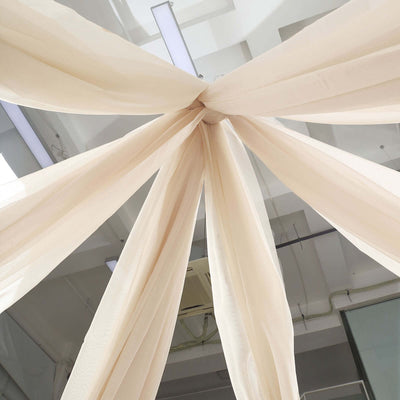 Sheer cream fabric draped from the ceiling in an artistic arrangement.