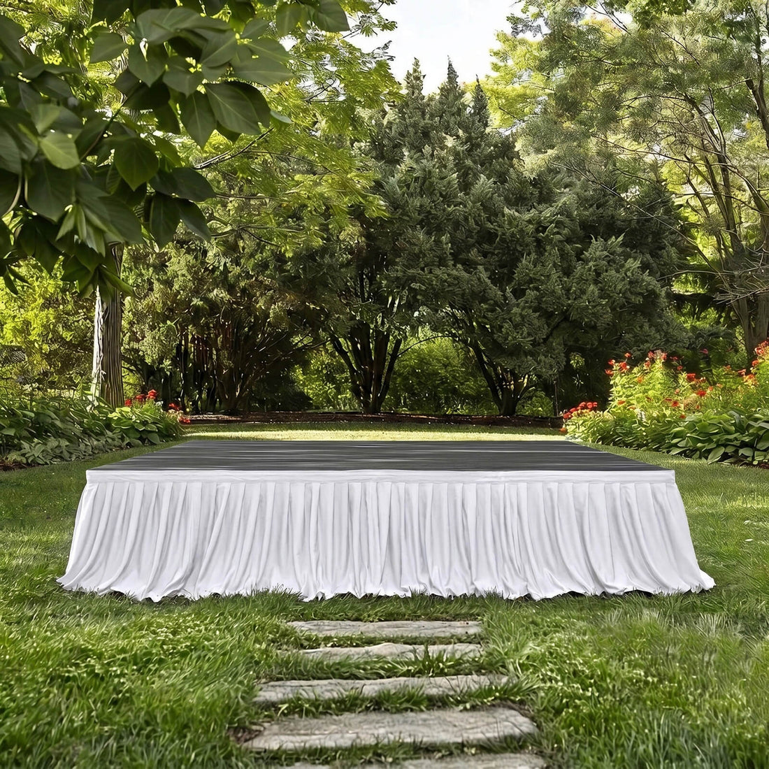 Elegant outdoor stage in a lush garden with white skirted table setting