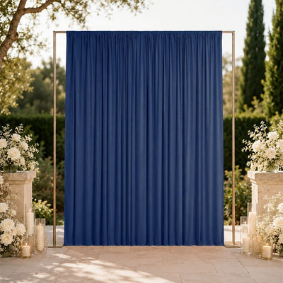 Elegant outdoor wedding backdrop with blue draped curtain and floral decor