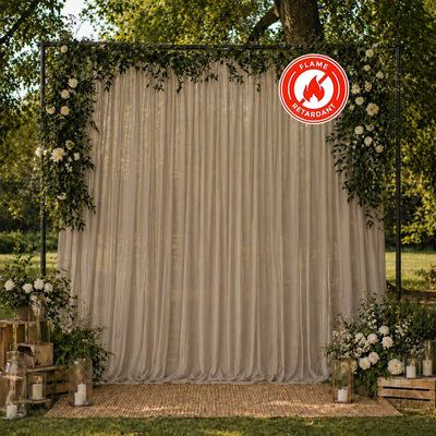 Elegant outdoor wedding backdrop with floral drapes and flame retardant sign