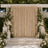 Elegant outdoor wedding backdrop with gold drapes, white flowers, and candles