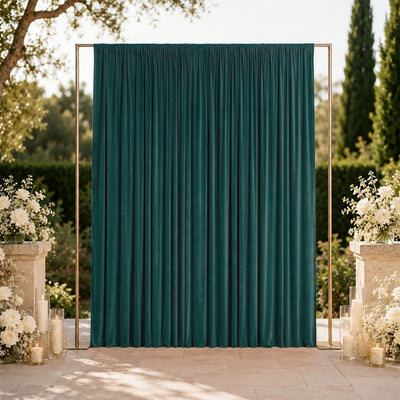 Elegant outdoor wedding backdrop with teal curtain and white floral arrangements
