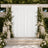 Elegant outdoor wedding ceremony arch with white drapery, flowers, and candles