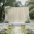 Elegant outdoor wedding ceremony setup with white floral arch and aisle petals