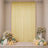 Elegant pastel party backdrop with yellow drape, flowers, candles, and balloons