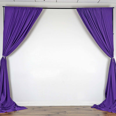 Purple drapery curtains hanging on a backdrop.