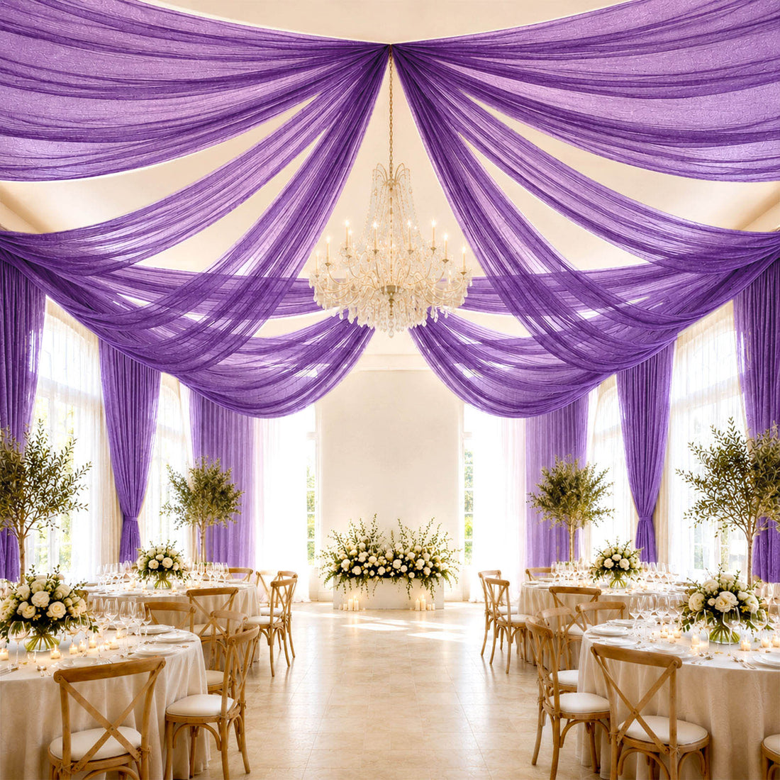 Elegant purple draped wedding reception with chandelier and floral centerpieces