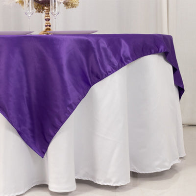 Purple satin tablecloth draped elegantly over a white table.