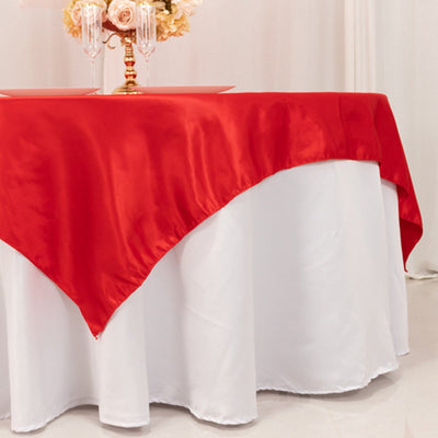 Red satin tablecloth draped elegantly over a white table.