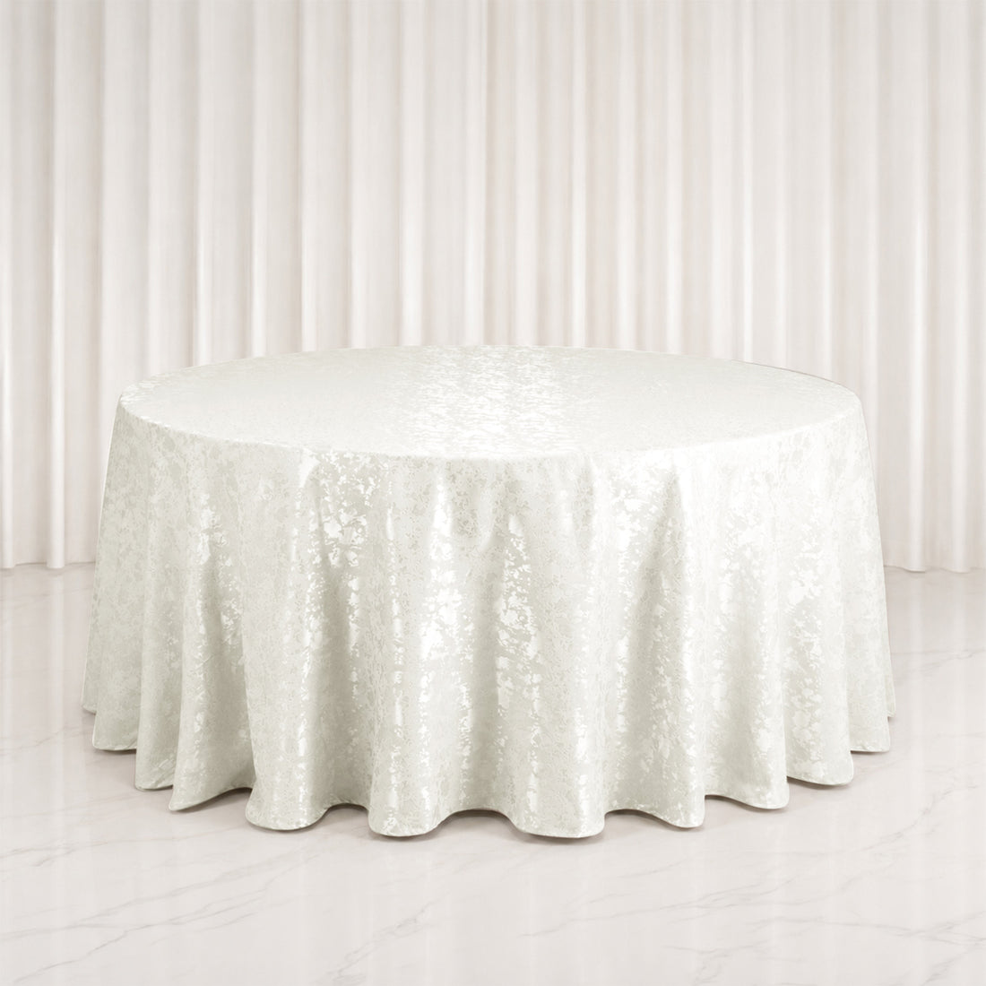 Elegant round white table with satin tablecloth in a minimalist setting