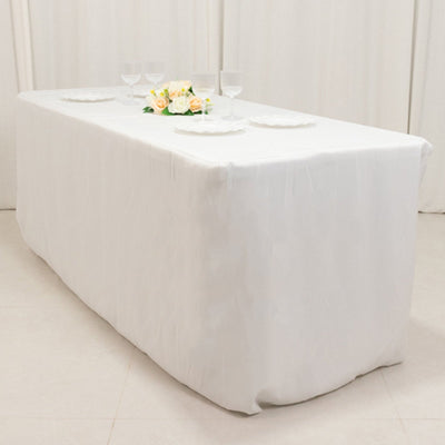 White table with floral centerpiece and glassware set for dining.