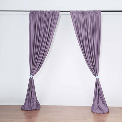 Purple curtains elegantly draped on a curtain rod against a white background.