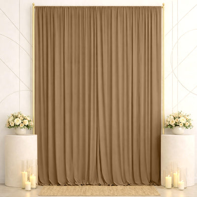 Elegant wedding backdrop with beige curtains, floral arrangements, and candles