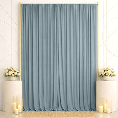Elegant wedding backdrop with blue drapes, floral arrangements, and candles