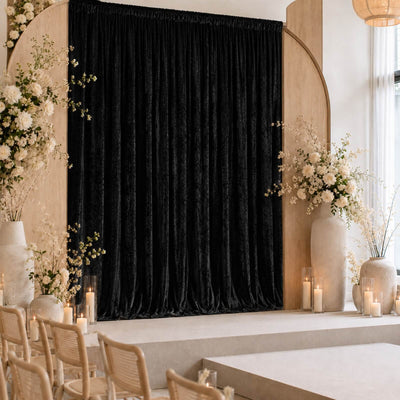 Elegant wedding ceremony stage with black velvet curtain and floral decor