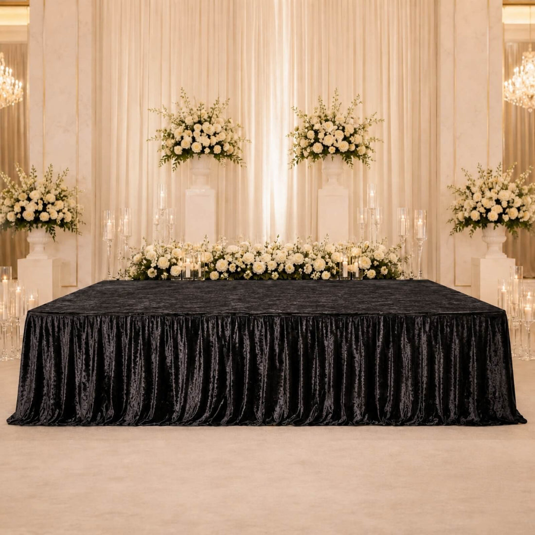 Elegant wedding reception backdrop with white roses, candles, and black velvet tablecloth