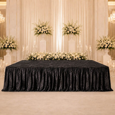 Elegant wedding reception backdrop with white roses, candles, and black velvet tablecloth
