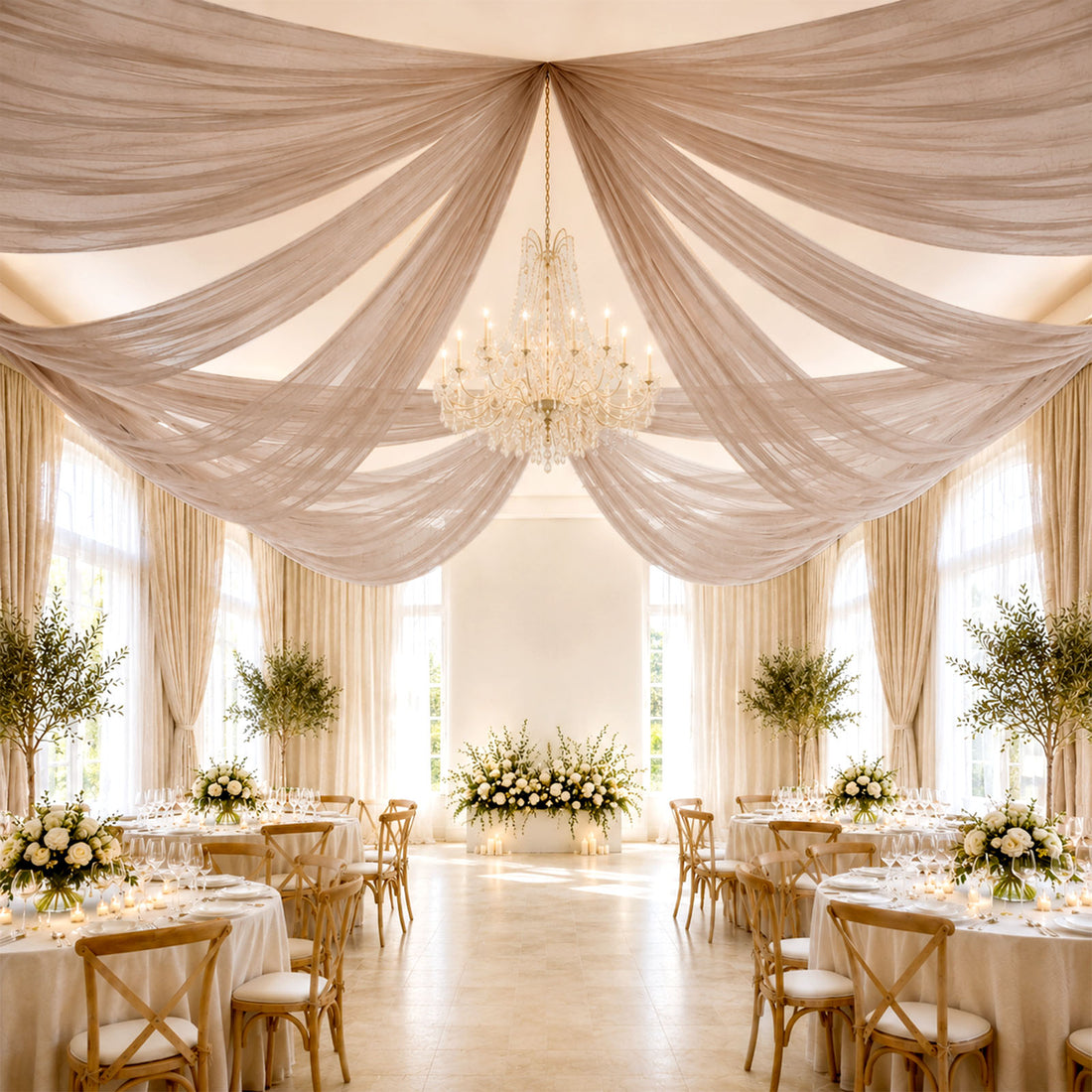 Elegant wedding reception hall with draped ceiling, chandelier, and floral tables