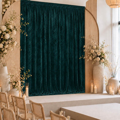 Elegant wedding stage with emerald velvet curtain and floral arrangements
