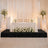 Elegant wedding sweetheart table with white roses, candles, and gold chairs