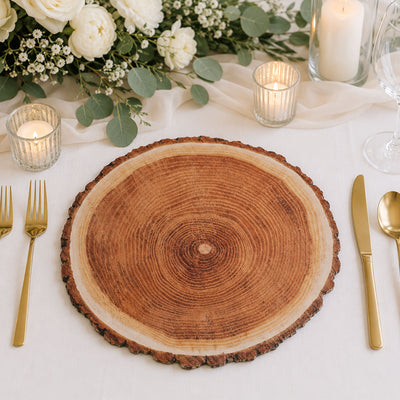 Elegant wedding table setting with wood slice charger, gold cutlery, and candles