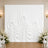 Elegant white draped wedding backdrop with floral arrangements and chairs
