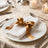 Elegant white napkin with gold ribbon on fine dining table setting