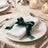 Elegant white napkin with green ribbon on formal dining table setting