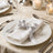 Elegant white napkin with silver ribbon on a formal dining table setting