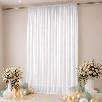 Elegant white sheer curtain backdrop with floral arrangements and pastel balloons