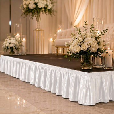Elegant white wedding stage with floral arrangements and candle decor