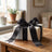Elegant wrapped gift box with black ribbon on rustic wooden table