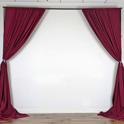 Maroon curtain drapes on a backdrop, creating a stylish photo setting.