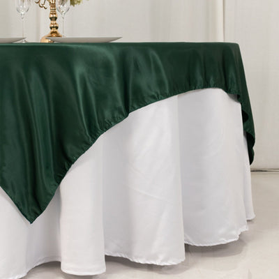 Green satin tablecloth draped over a white table.